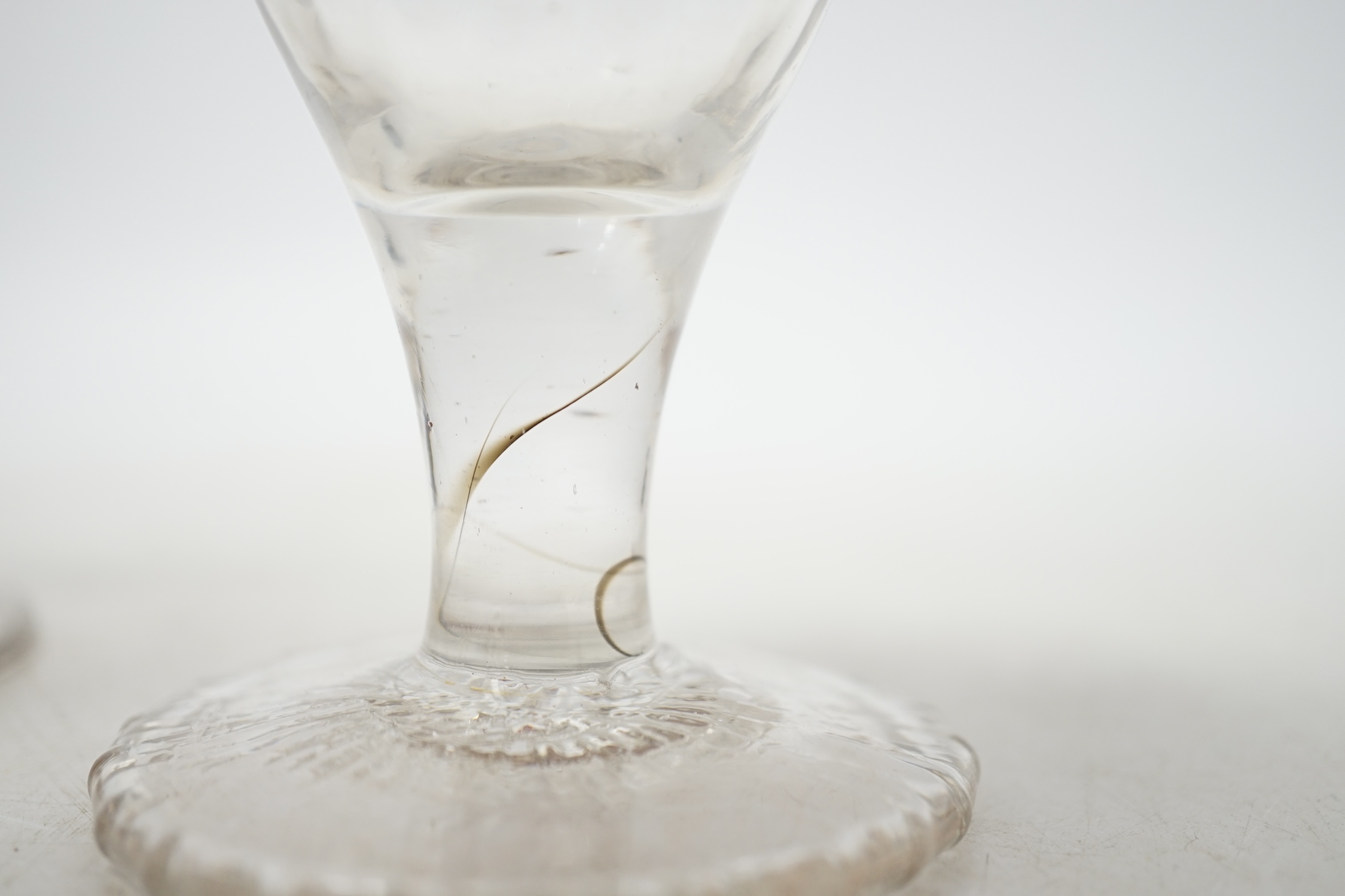 A mid 18th century wine glass with over-sewn foot and four others, three with knopped stems, tallest 10.5cm. Condition - good